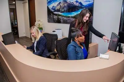 front desk staff at Mills Dental Group in Houston, TX scheduling appointments for patients