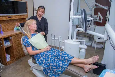 Diana, Mills Dental Group's dental hygienist, getting a patient ready for her oral surgery procedure